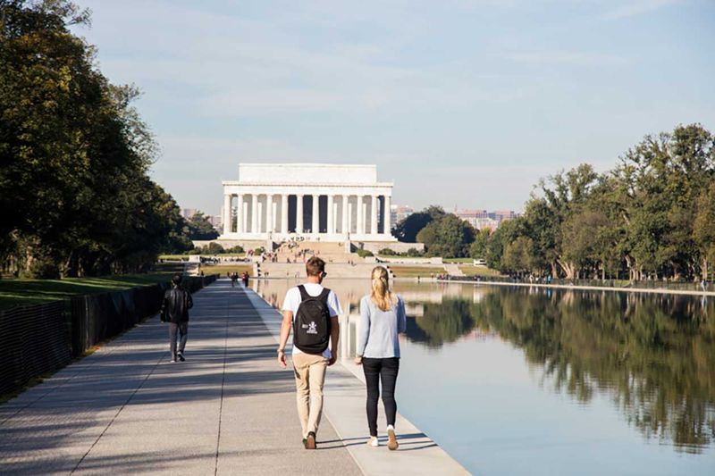 Two people walking beside the Lincoln Memorial Reflecting Pool