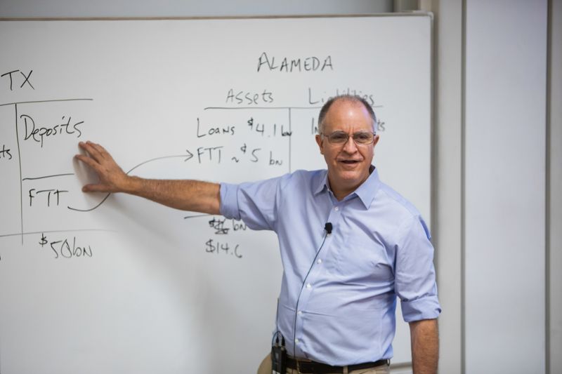A professor teaching an Executive MBA class at the whiteboard